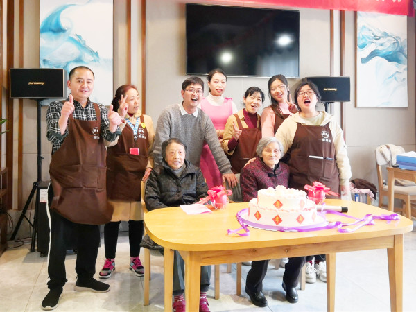 华阳养老院一暄康养生日会上工作人员和寿星合影