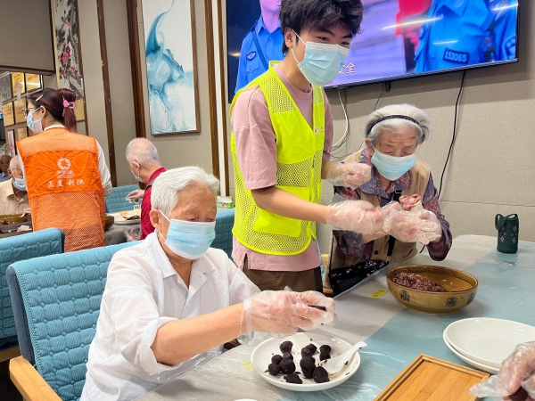 志愿者带着奶奶做月饼馅儿