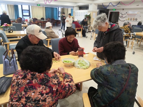 成都日间照料中心一暄康养三两长者相约剥胡豆2